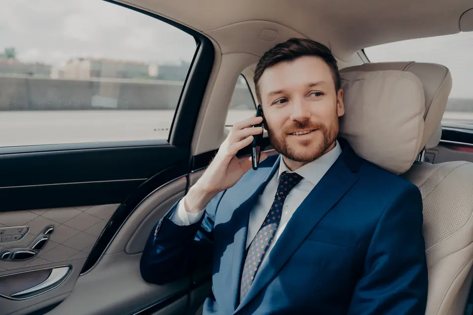 Executive passenger relaxing in the back seat of a luxury car